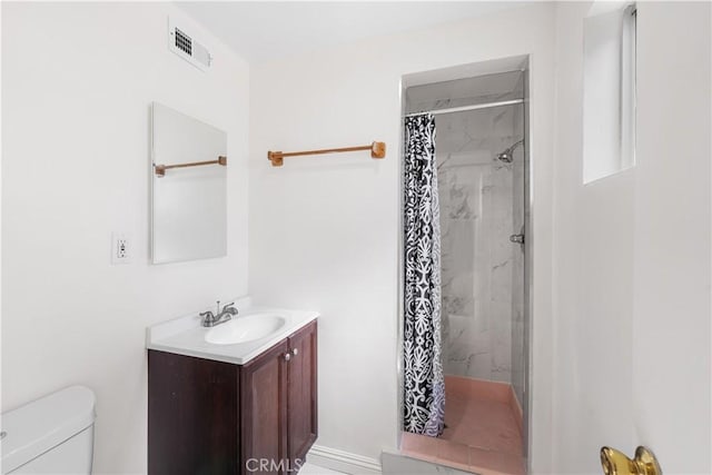 bathroom featuring toilet, a stall shower, visible vents, and vanity