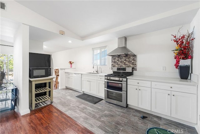 kitchen with a sink, wall chimney range hood, black microwave, double oven range, and dishwasher