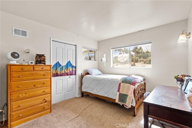 carpeted bedroom featuring visible vents