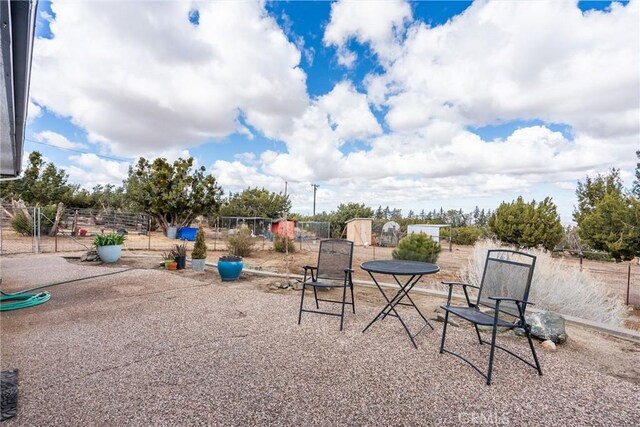 view of yard with a patio area, a storage unit, an outdoor structure, and fence