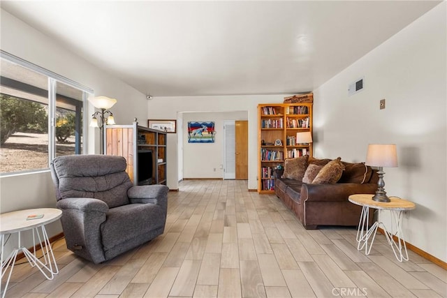 living area featuring visible vents, baseboards, and light wood-style floors