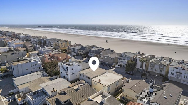 aerial view featuring a view of the beach, a water view, and a residential view