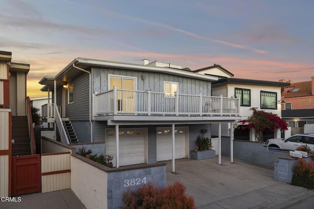 view of front of house with driveway, an attached garage, and stairs