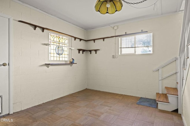 basement with concrete block wall and stairs