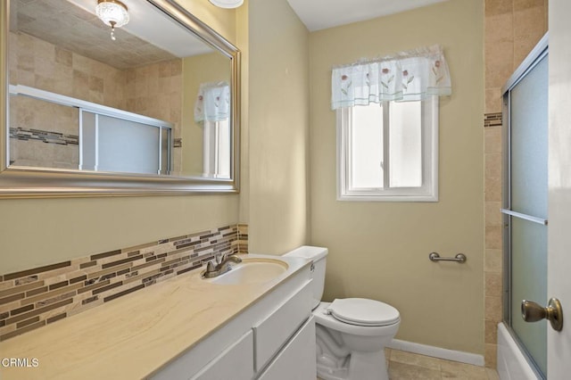 bathroom with baseboards, toilet, tiled shower / bath combo, vanity, and backsplash