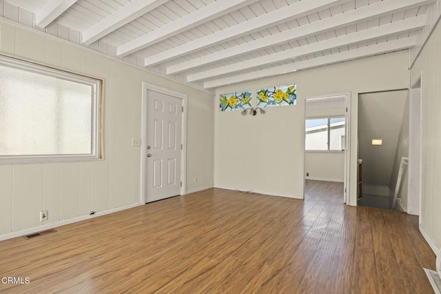 interior space with wooden ceiling, visible vents, baseboards, beam ceiling, and light wood finished floors