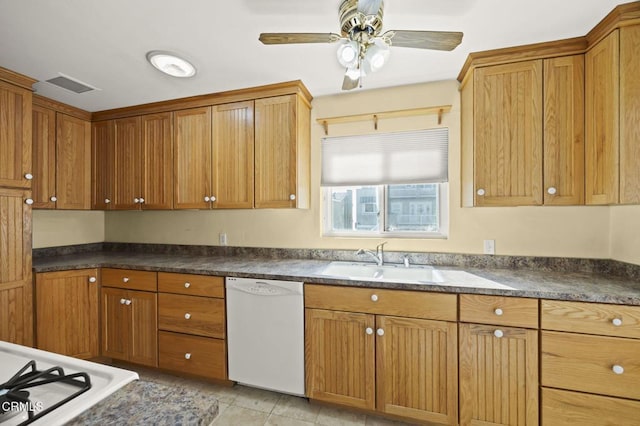 kitchen with dishwasher, dark countertops, a sink, and a ceiling fan