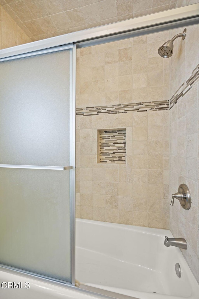 bathroom featuring bath / shower combo with glass door