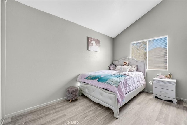 bedroom with vaulted ceiling, baseboards, and wood finished floors