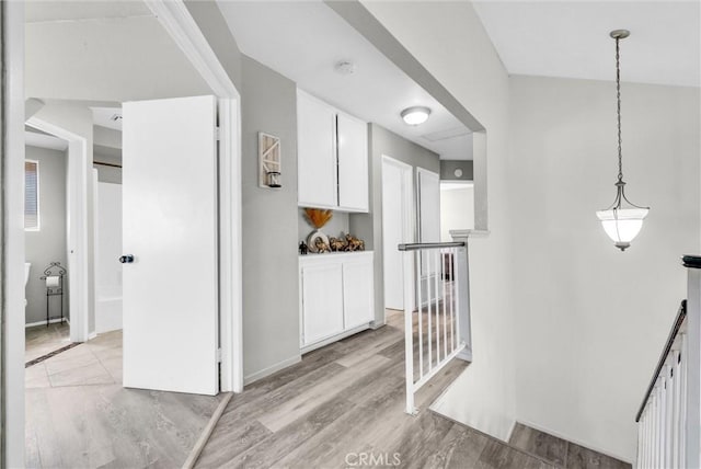 corridor featuring light wood-style flooring and an upstairs landing