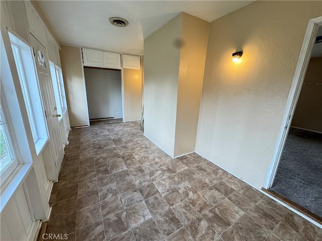 spare room featuring stone finish floor and visible vents