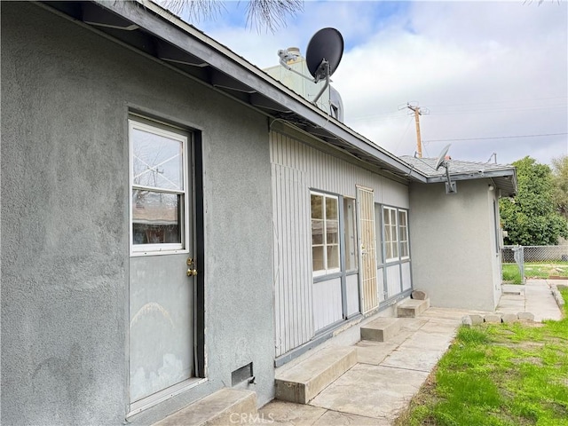 view of side of property featuring fence and stucco siding