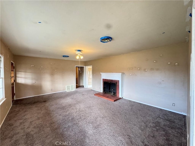 unfurnished living room featuring carpet floors, a brick fireplace, baseboards, and visible vents