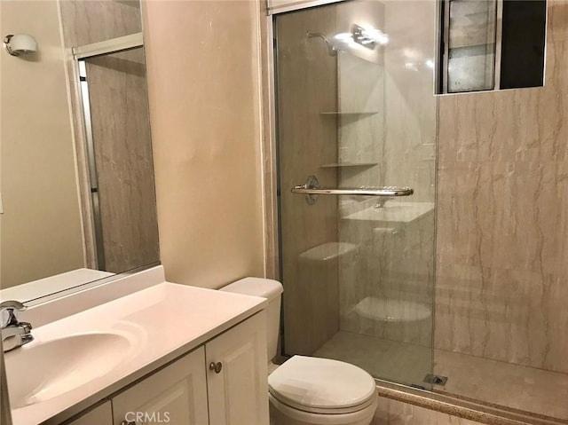 bathroom featuring a stall shower, vanity, and toilet