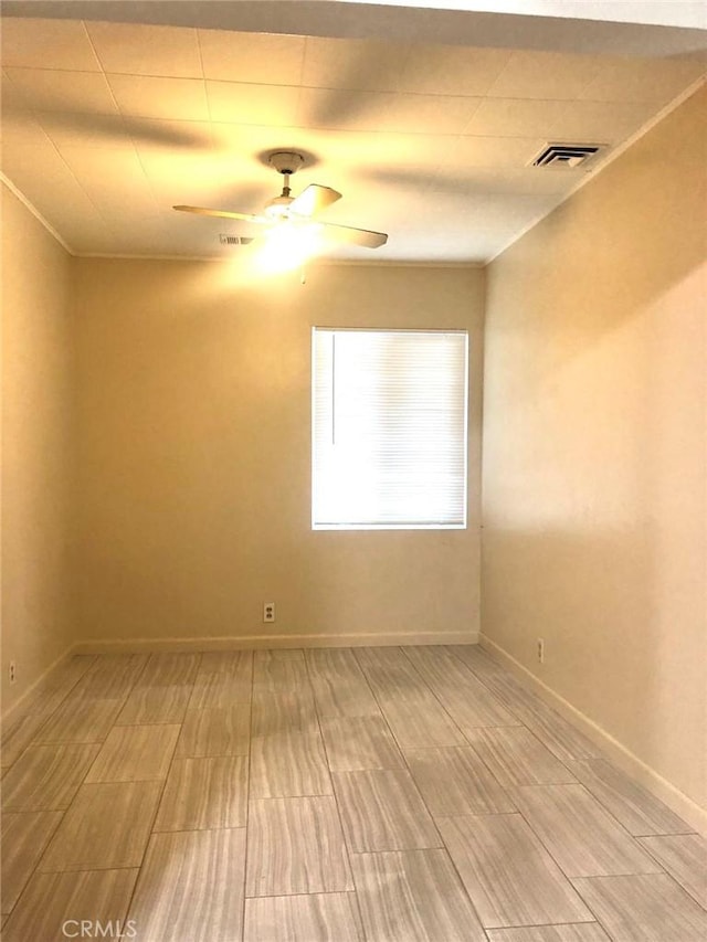 unfurnished room with ceiling fan, visible vents, and baseboards