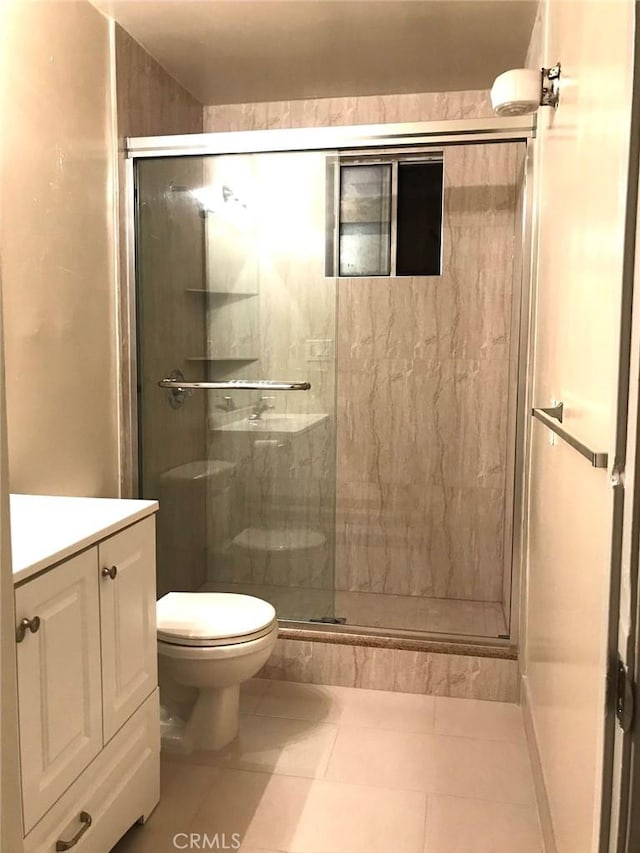 bathroom featuring toilet, a shower stall, tile patterned flooring, and vanity