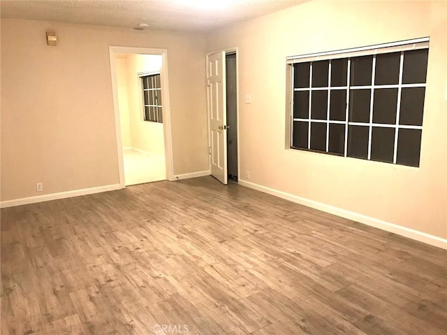 spare room featuring wood finished floors and baseboards