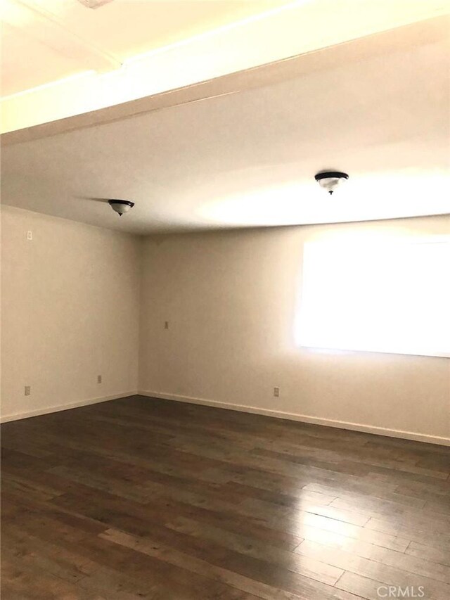 unfurnished room featuring dark wood finished floors and baseboards