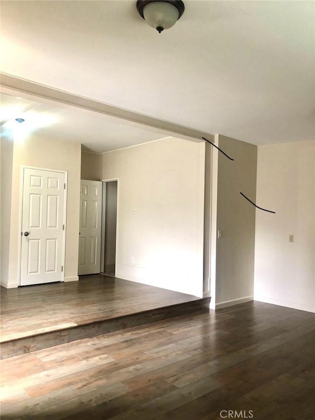 unfurnished room featuring wood finished floors and baseboards