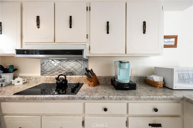 kitchen featuring light countertops, white cabinetry, and range hood