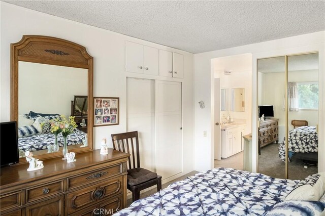 bedroom with a textured ceiling, a closet, and light colored carpet