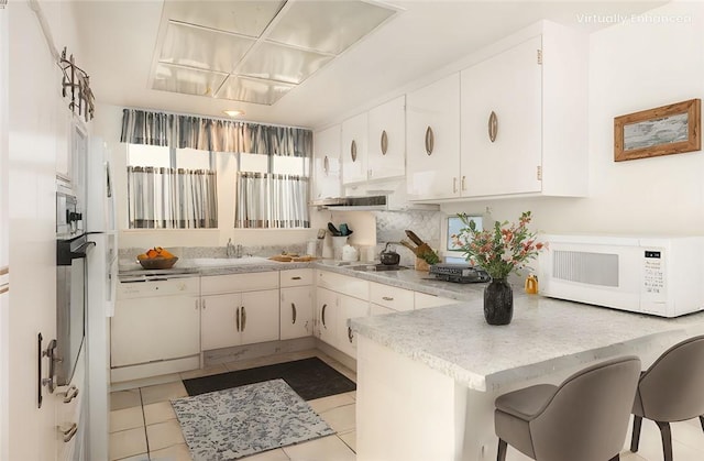 660 Avenida Sevilla Unit P, Laguna Woods, CA 92637 - kitchen with white appliances, a peninsula, light countertops, and white cabinetry