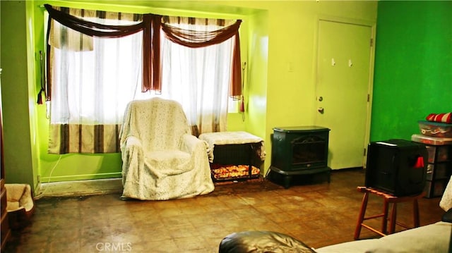 sitting room with a wood stove and tile patterned floors