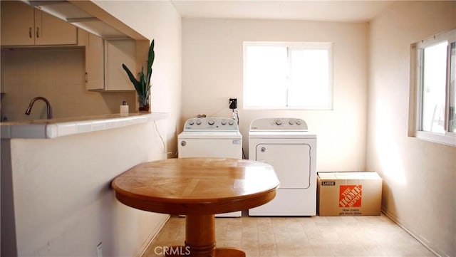 washroom featuring a sink, laundry area, and washing machine and clothes dryer