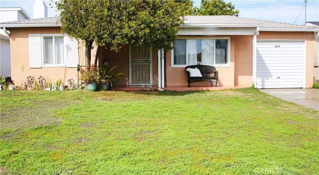 back of house with an attached garage, a lawn, and stucco siding