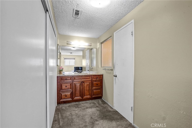 bathroom with a textured ceiling, visible vents, and vanity