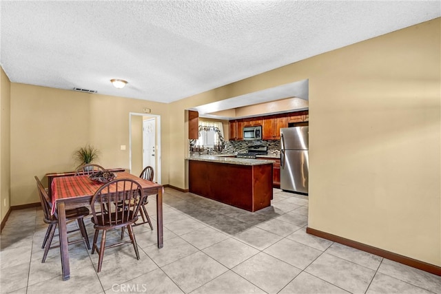 dining space featuring light tile patterned floors, a textured ceiling, visible vents, and baseboards