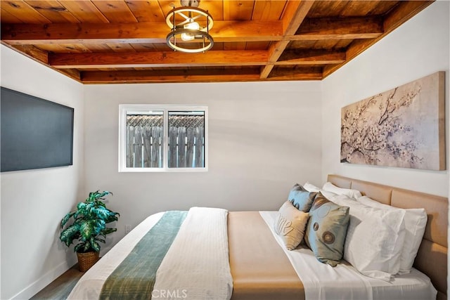 bedroom featuring beam ceiling, wood finished floors, and wood ceiling