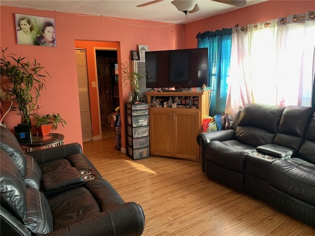 living area with light wood-style floors and a ceiling fan