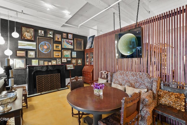 dining room with concrete flooring and a fireplace