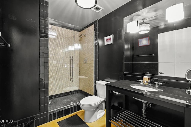 full bathroom with toilet, a stall shower, visible vents, and a sink