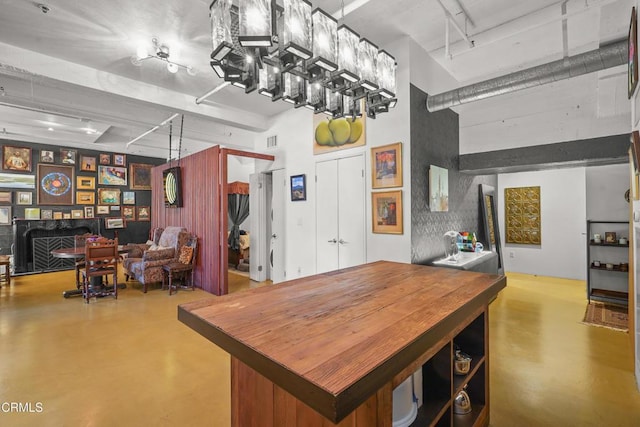 dining space with concrete flooring, a high ceiling, a fireplace, and visible vents