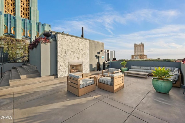 view of patio / terrace featuring a view of city and an outdoor living space with a fireplace