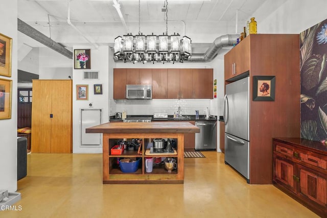 kitchen featuring stainless steel appliances, butcher block countertops, visible vents, finished concrete flooring, and decorative backsplash