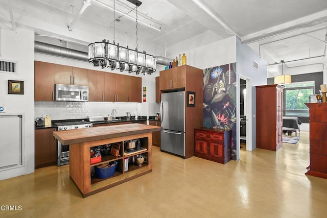 kitchen with finished concrete flooring, tasteful backsplash, visible vents, butcher block countertops, and stainless steel appliances