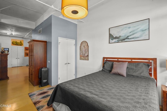 bedroom with visible vents, concrete flooring, and a closet