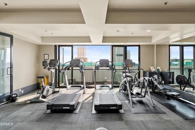 exercise room with a view of city, floor to ceiling windows, and plenty of natural light