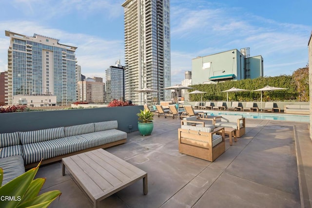 view of patio with an outdoor hangout area, a community pool, and a city view