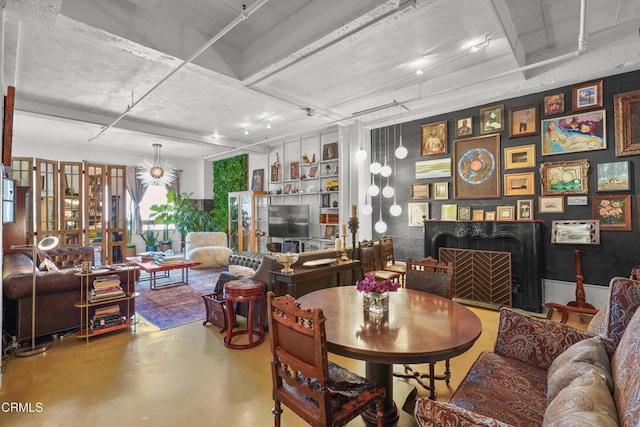 dining room with a fireplace and finished concrete floors