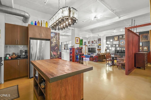 849 S Broadway Unit M11, Los Angeles, CA 90014 - kitchen with wooden counters, freestanding refrigerator, decorative backsplash, finished concrete flooring, and open floor plan