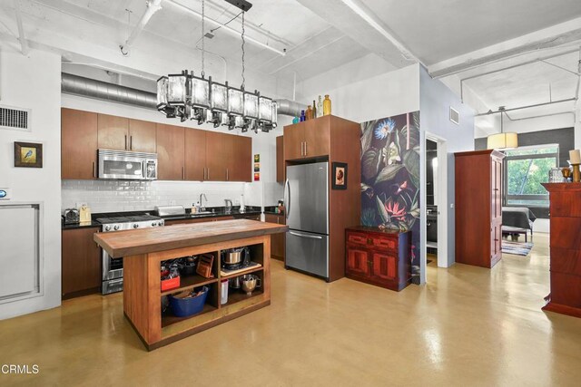 849 S Broadway Unit M11, Los Angeles, CA 90014 - kitchen featuring appliances with stainless steel finishes, wooden counters, tasteful backsplash, and concrete flooring