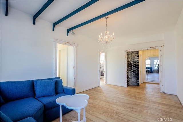 living room featuring an inviting chandelier, light wood-style flooring, baseboards, and beam ceiling