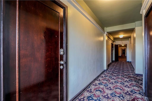 corridor with carpet flooring and baseboards