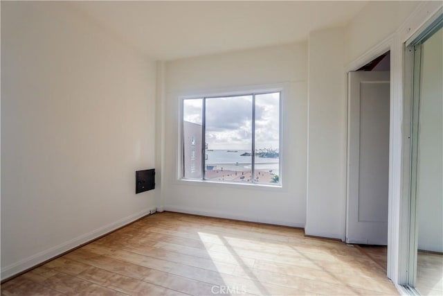 unfurnished room featuring light wood finished floors and baseboards