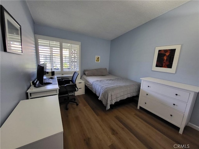 bedroom with dark wood-style floors and a textured ceiling