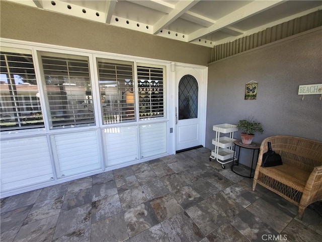 doorway to property featuring stucco siding